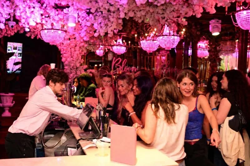 Guests being served cocktails at the bar under the cherry blossom at a Christmas party at Bloom, Park Street, Bristol